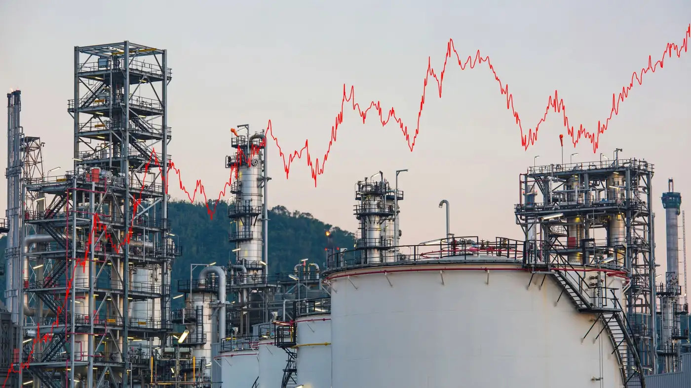 planta de refinación de petróleo con un grafico de precios con línea roja al alza